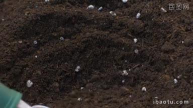 用手铲把泥土和肥料混合在一起